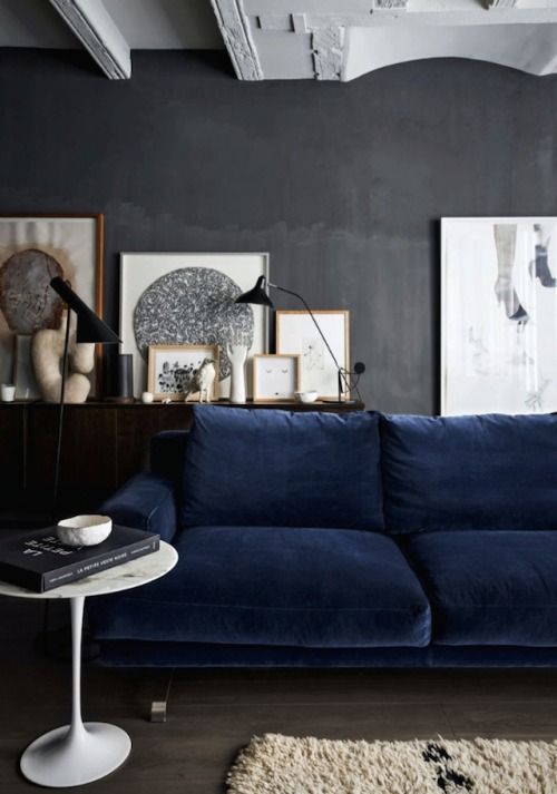 dark grey wall, dark floor, dark blue sofa, white accents; nice .
