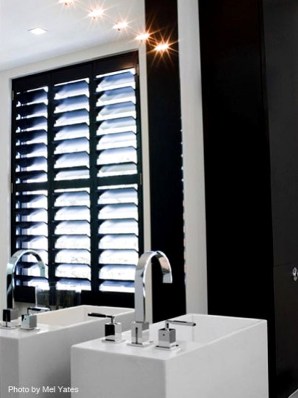 Black wooden interior shutters | Black and white bathroom floor .